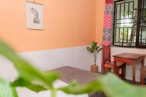 a room with a table and a chair and a window at Laughing Goat Ghana in Busua