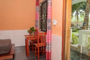 a room with a desk and a table with a window at Laughing Goat Ghana in Busua