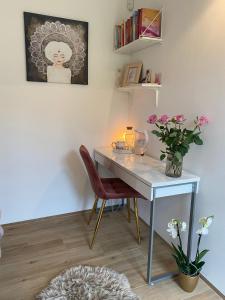 a desk in a room with a vase of flowers at River & Forest Escape, Private Garden Room near Ljubljana in Preddvor