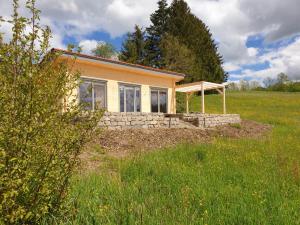 a small house in a field next to a field at Ferienhaus Summerwiese in Ochsenhausen