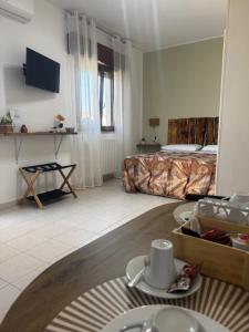 a hotel room with a bed and a table with dishes at Il Rifugio delle Allodole in Leporano Marina