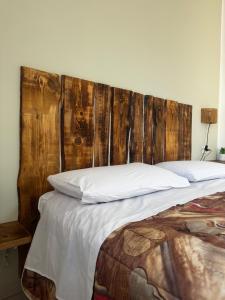 a bedroom with a wooden headboard and a bed at Il Rifugio delle Allodole in Leporano Marina