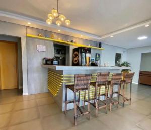 a bar in a room with four stools at pousada das manas in Torres