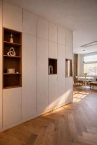 a living room with white cabinets and a table at Stylish City Center Escape- Where Modern Elegance Meets History in Trier