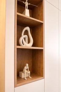 a wooden shelf with a figurine sitting on a box at Stylish City Center Escape- Where Modern Elegance Meets History in Trier +117 photos