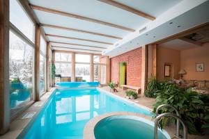 uma piscina interior com água azul numa casa em Marcienas Muiza & SPA em Mārciena