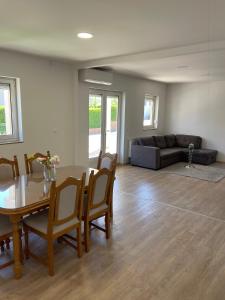 a living room with a table and chairs and a couch at Elbas Apartman in Široki Brijeg