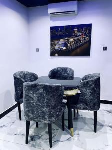 a table and chairs in a room with a painting at Spike apartments in Jibowu +7 photos