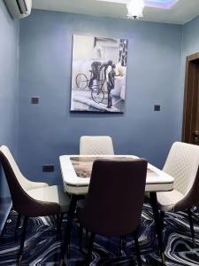 a table and chairs in a room with a picture on the wall at Spike apartments in Jibowu