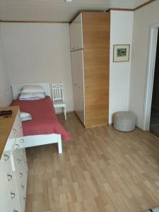 a bedroom with a bed with a red blanket and a desk at Retrokodu in Rakvere
