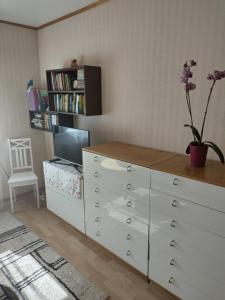 a room with a dresser with a tv and a dresser with a flower at Retrokodu in Rakvere