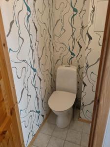 a bathroom with a toilet and a wall with wallpaper at Retrokodu in Rakvere +4 photos