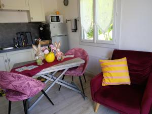 a small kitchen with a table and two chairs at Au fil des mains in Le Houga
