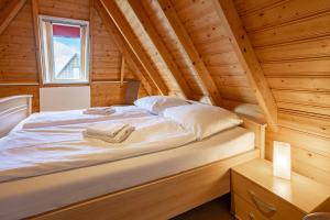 a bed in a log cabin with a window at Ferienhaus Klapötke in Dorum-Neufeld +32 photos