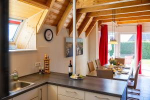 a kitchen and dining room with a table and a clock at Ferienhaus Klapötke in Dorum-Neufeld