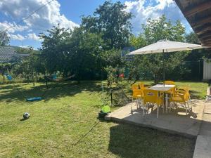 a table and chairs with an umbrella in a yard at Casa Noel in Târgu Ocna