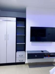 a living room with a tv and a entertainment center at Spike apartments in Jibowu