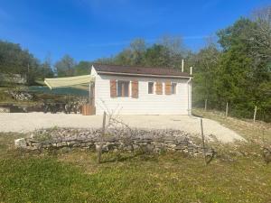 a small white house with a fence in front of it at Le petit coin du pêcheur in Brouchaud