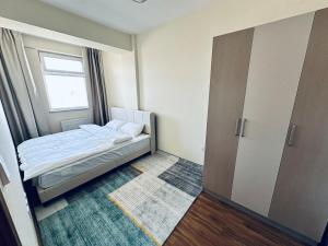 a small bedroom with a bed and a window at Comfy apartment near central train station in Ulaanbaatar