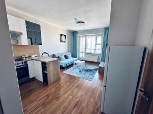 a kitchen and living room with a couch and a refrigerator at Comfy apartment near central train station in Ulaanbaatar