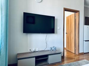 a living room with a flat screen tv on a wall at Comfy apartment near central train station in Ulaanbaatar