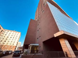 a tall building with cars parked in front of it at Comfy apartment near central train station in Ulaanbaatar