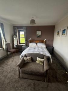 a bedroom with a large bed and a chair at The Greannan Bed & Breakfast in Blackwaterfoot