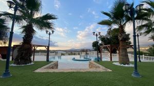 a swimming pool with palm trees and lights in a park at Mirador de Aledo in Aledo