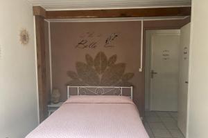 a bedroom with a bed with a flower on the wall at Le petit coin du pêcheur in Brouchaud