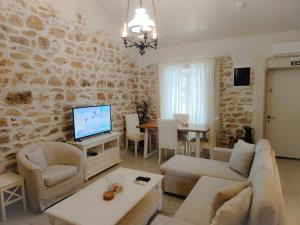 a living room with a couch and a tv at Spiti Mata in Perítheia