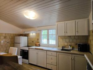 a kitchen with white cabinets and a white refrigerator at Spiti Mata in Perítheia +17 photos