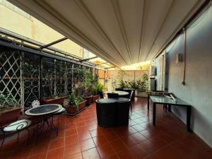 a patio with tables and potted plants in a building at B&B Elisir in Albenga