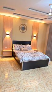 a bedroom with a bed with two lamps on it at llc APARTMENT in Kumasi