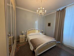 a bedroom with a large bed and a chandelier at B&B Elisir in Albenga