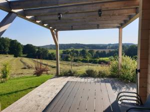 a wooden deck with a view of the countryside at Ferienhaus Summerwiese in Ochsenhausen +3 photos