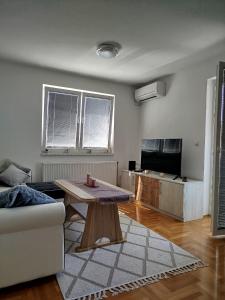 a living room with a table and a couch at Smjestaj_S in Bijeljina