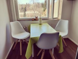 a dining room table with three chairs and a window at Yyterin Kontu in Pori +6 photos