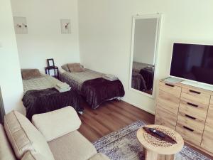 a living room with a couch and a tv and a mirror at Yyterin Kontu in Pori