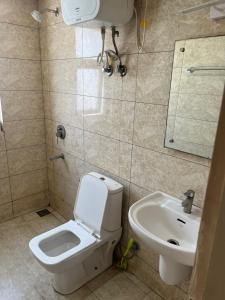 a bathroom with a toilet and a sink at Vrindavan Viharini Kunj in Chhatikara