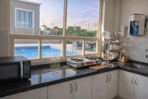 a kitchen with a view of a swimming pool through a window at Summit Springs Resorts in Bagru