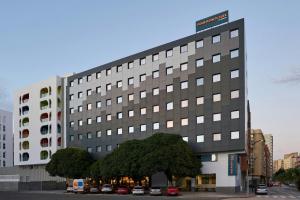 a large building with a tree in front of it at Four Points Flex by Sheraton Malaga Centre in Málaga