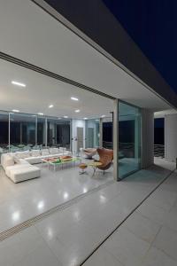 a living room with white furniture and glass walls at Villa Paleopoli in Kythira