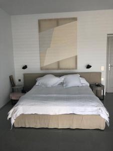 a bedroom with a large bed with a painting on the wall at Villa Paleopoli in Kythira +33 photos