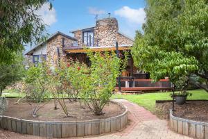 a stone house with trees in front of it at The Enchanted Stone Cottage in Margaret River Town