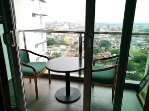 a table and chairs in a room with a window at NF Suites D'Perdana Condo in Kota Bharu
