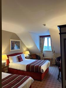 a hotel room with two beds and a window at Viking House Hotel Donegal in Kincasslagh