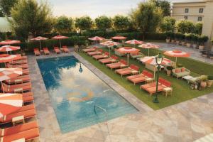 an overhead view of a pool with chairs and umbrellas at The Stoneleigh, Autograph Collection in Dallas