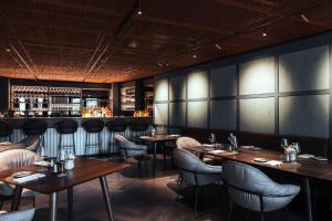 a restaurant with tables and chairs and a bar at Central by Residence Hotel in Vaduz