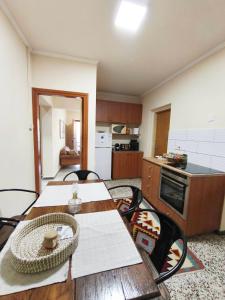 a kitchen with a wooden table and a table and chairs at Casa del Kampos in Kambos