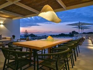 a long wooden table and chairs on a patio at Villa Katy in Aspro Chorio Paros